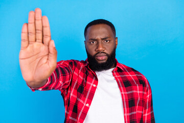 Photo of sad millennial brunet guy show stop sign wear red shirt isolated on blue color background