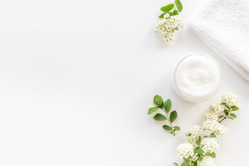 Obraz na płótnie Canvas White moisturizing cream cosmetic for spa treatment with blossoms flowers