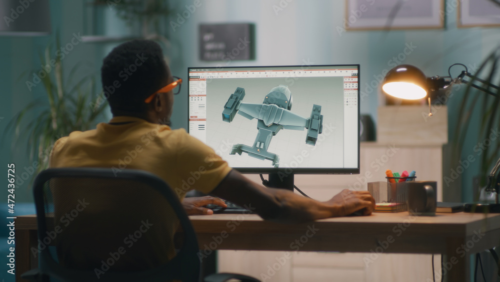 Fototapete black man using computer and creating 3d model of futuristic aircraft for videogame or movie while w