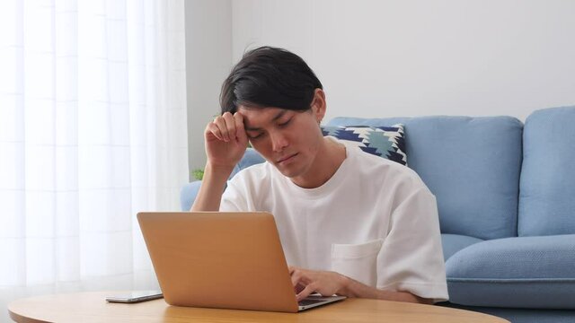 男性　パソコン　リビング　悩む