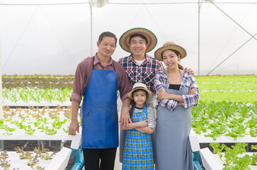 Happy farmer family working in hydroponic greenhouse farm, clean food and healthy eating concept