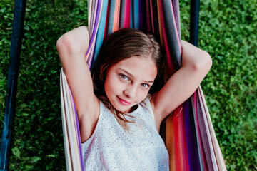 Brown eyed girl resting in hammock at garden