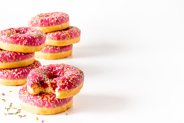 Group of pink frosted donuts with colorful sprinkles