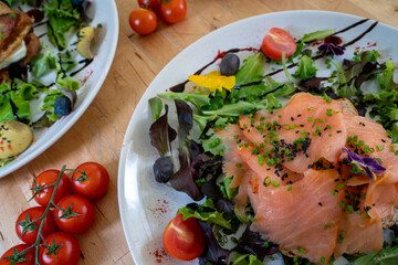 Danish open sandwich Smorrebrod with salmon on rye bread with vegetables and herbs
