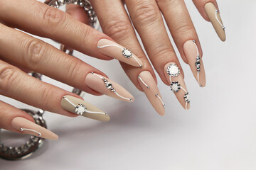 Nude manicure with rhinestones on long nails.