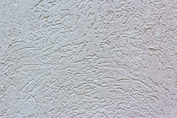 Decorative white wall plaster pattern stylized in bark beetle texture. The white texture of the surface of the wall covered with decorative plaster of the woodworm type, close-up abstract background