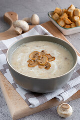 Mushroom soup with flavored croutons on the board.