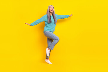 Fototapeta na wymiar Full length body size view of attractive cheerful carefree granny having fun like plane isolated on vivid yellow color background
