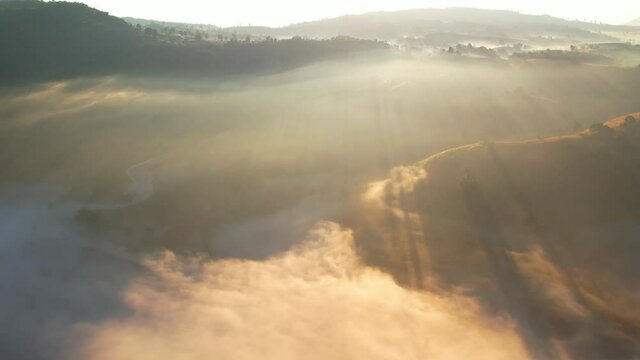 4K Scenic flight over beautiful mountain scape with bright sky and fog clouds on summer sunrise. Flight above clouds
