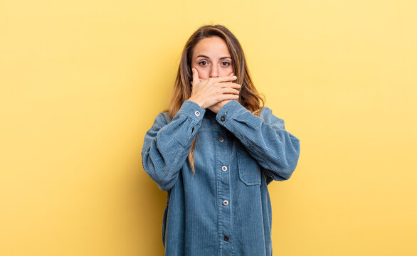 pretty caucasian woman covering mouth with hands with a shocked, surprised expression, keeping a secret or saying oops