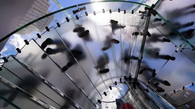 Slow motion of people moving and walking along a modern staircase. Business concept. Footprints from a position underneath