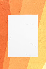 Closeup of geometrical orange yellow painted urban wall texture with wrinkled glued poster...