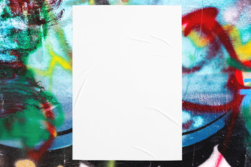 Closeup of colorful messy painted urban wall texture with wrinkled glued poster template . Modern mockup for design presentation. Creative urban city background. 