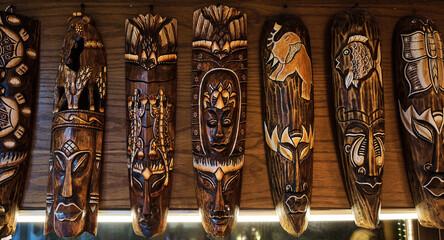 Many authentic African totems on wall at oriental souvenir shop