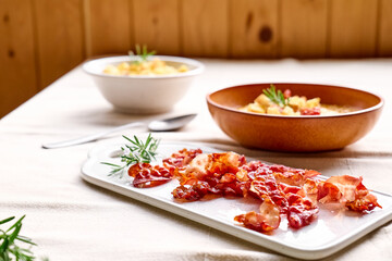 Roasted bacon for pumpkin cream soup with croutons in clay plate on the table with linen tablecloth. Autumn vegetable creamy soup puree. Healthy seasonal eating.