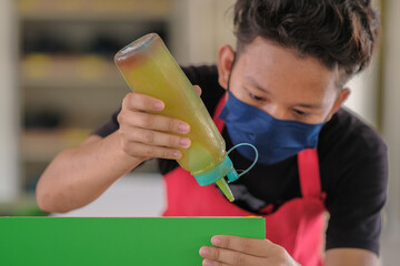 Young carpenters use contact glue in installing laminate for built-in cabinets at the workshop.