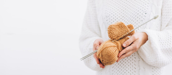 Women's hands hold natural wool threads for knitting, knitting needles. Close up, selective soft...