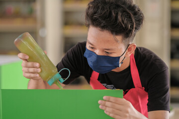 Young carpenters use contact glue in installing laminate for built-in cabinets at the workshop.