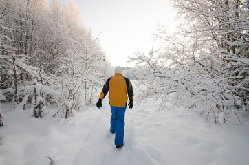 A man walking through a beautiful snowy forest 