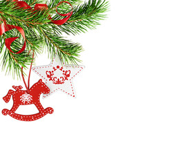 Christmas corner arrangement with green pine twigs, red and white painted wooden decorations and satin ribbons isolated on white