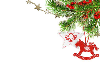 Christmas corner arrangement with green pine twigs, red and white painted wooden decorations and red berries isolated on white