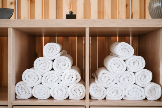 White rolled up towels stacked in wooden rack at pilates studio