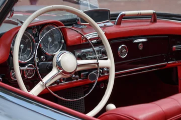 Deurstickers Oldtimer mit rotem Leder Innenraum und weißem Lenkrad mit Radio und Tacho Armaturen © Bigwuschel
