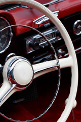 Wei&szlig;es Lenkrad eines Oldtimers mit rotem Leder Innenaum