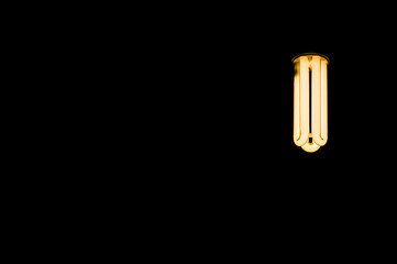 Luminous tubes of a fluorescent lamp on a black background. Selective focus, copy space