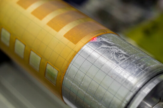 Blurred cylinder with glued flexographic printing form from a photopolymer. Preparation of equipment for printing self-adhesive labels. Selective focus