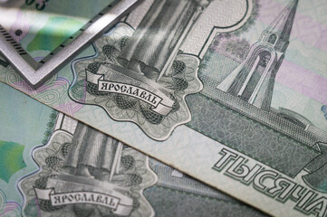 Verification of Russian banknotes for authenticity under a magnifying glass. Used money. Selective...