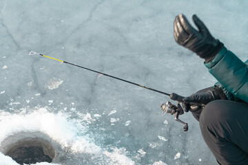 Holding fishing rod while ice fishing