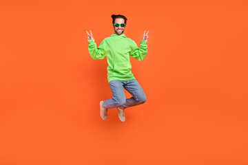 Fototapeta na wymiar Full body photo of brunet millennial guy jump wear sweatshirt jeans shoes eyewear isolated on orange background