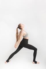 Young woman with sports figure is engaged in yoga. Yoga instructor side view on white background.