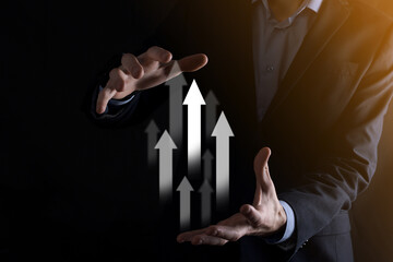 Business man holding holographic graphs and stock market statistics gain profits. Concept of growth planning and business strategy. Display of good economy form digital screen