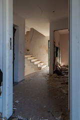 An old staircase in an abandoned house with an interior destroyed by vandals