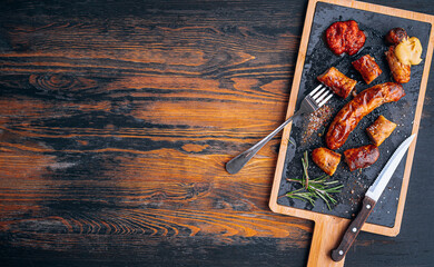 fried sausages with sauces and spices on a stone plate