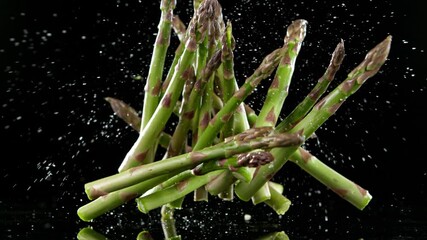 Super slow motion of falling green asparagus. Filmed on high speed cinematic camera at 1000 fps. - Powered by Adobe