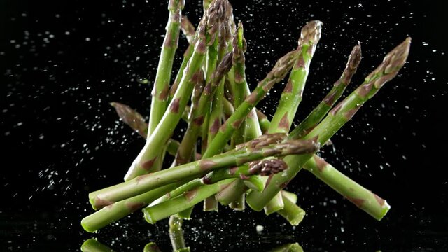 Super slow motion of falling green asparagus. Filmed on high speed cinematic camera at 1000 fps.