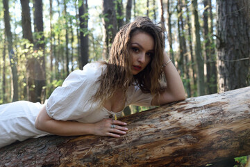 Pretty, young woman posing in the forest. Green surroundings during spring in Poland.