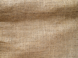 A piece of burlap with folds. Coarse textured surface.