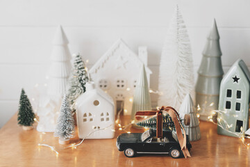 Holidays coming! Christmas scene, car with tree and miniature holiday village. Merry Christmas!
