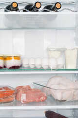 refrigerator filled with food and bottles of wine