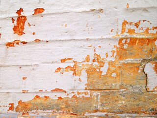 Brick wall covered with bright juicy orange and white paint.