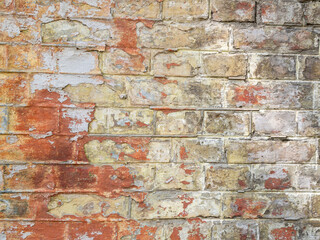 Brick wall with bright spots of paint.