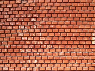 A large fragment of a red brick wall with narrow masonry. Bright abstract background.