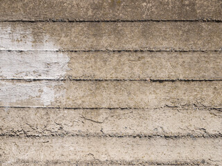 Part of a concrete surface with rough joints and stains of white paint.