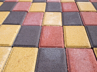 A side view of a colorful coating of yellow, red and black tiles.