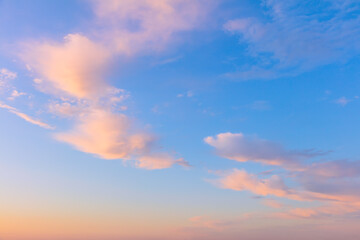 Naklejka na ściany i meble Light cirrus clouds in the blue sky during dawn sunset, real pastel colors