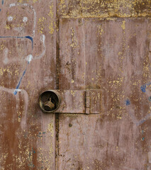 fragment of a metal door with a padlock, close-up, old paint peeled off